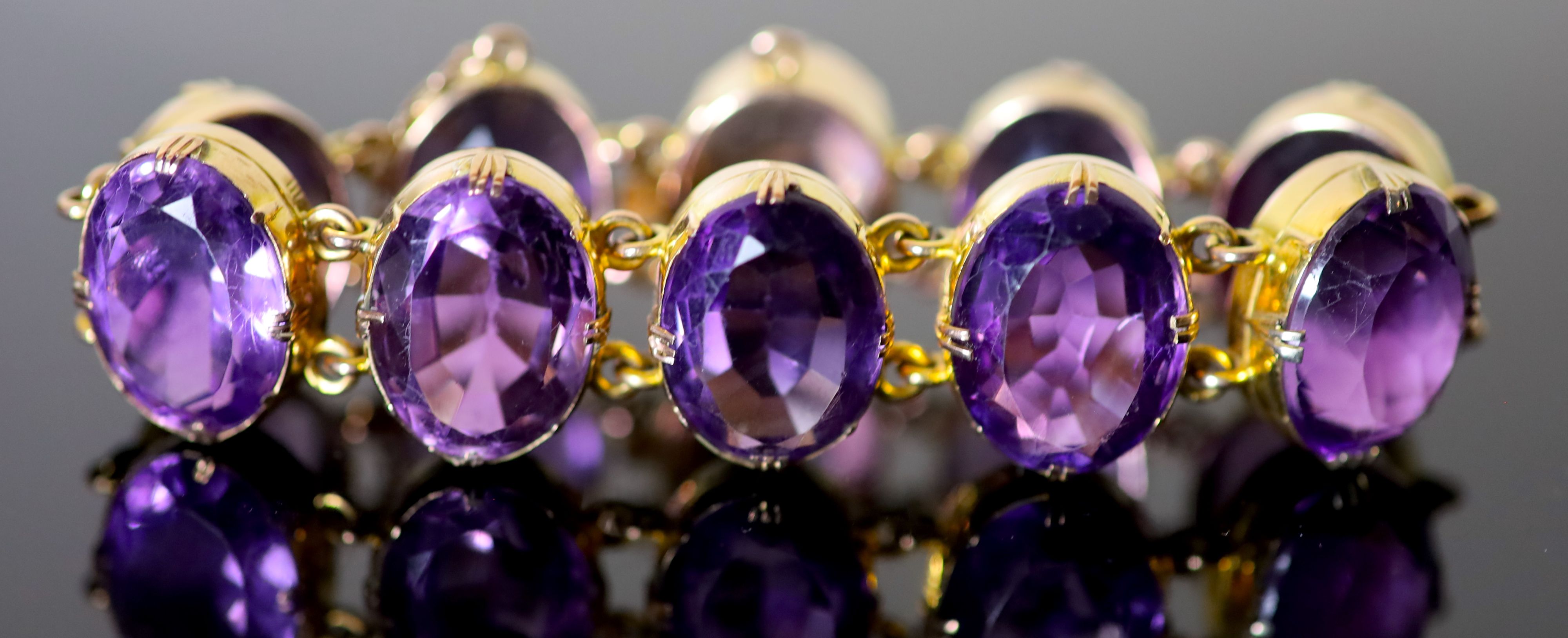 A Victorian style gold and ten stone oval cut amethyst set bracelet,